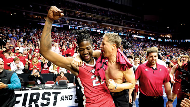 Arkansas Razorbacks head coach Eric Musselman celebrates with forward Makhel Mitchell after defeating the Kansas Jayhawks at Wells Fargo Arena.